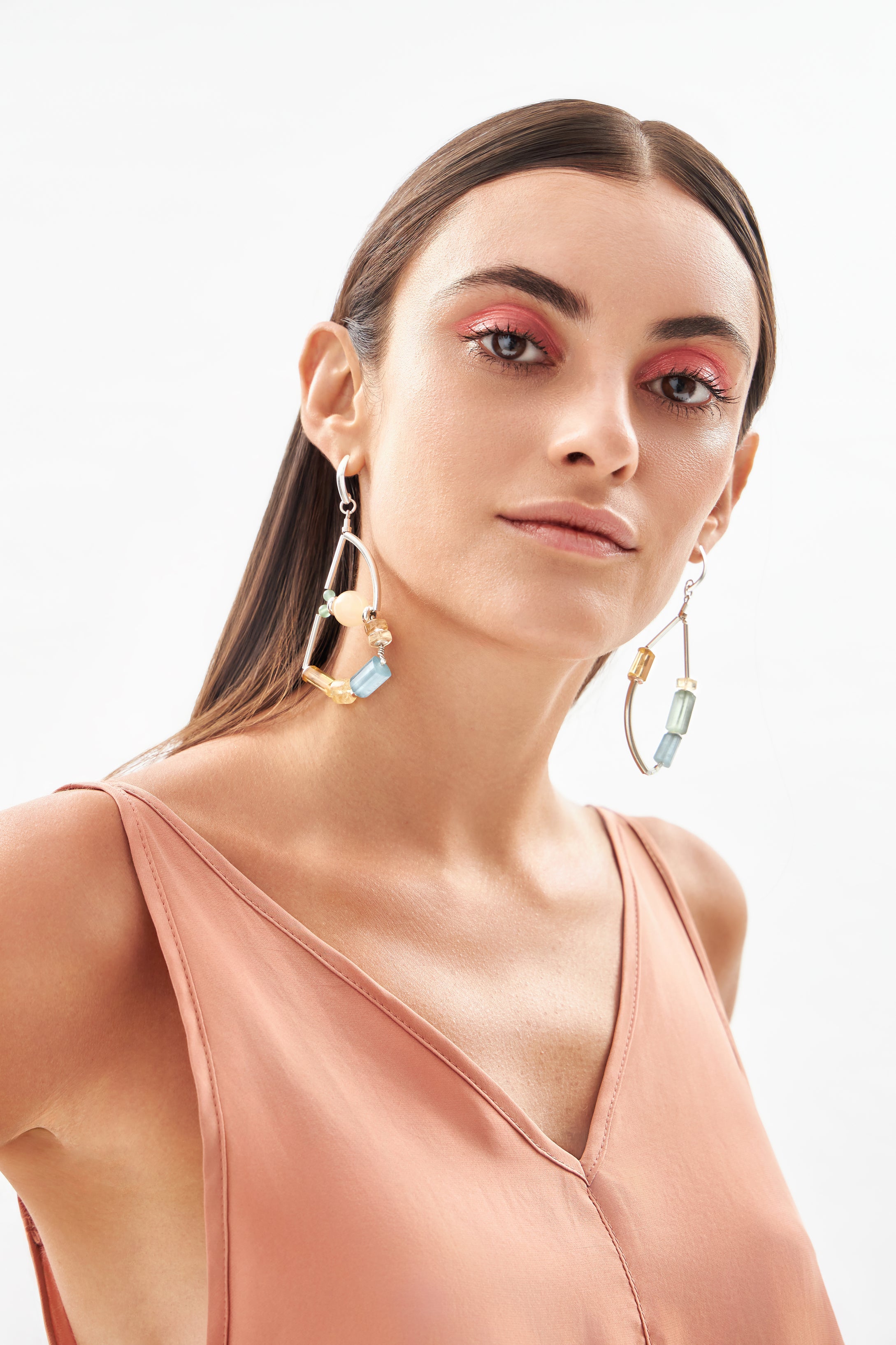 Modelo usando brincos Couture em prata 925 com água-marinha, ágatas, calcita amarela e citrinos naturais da A'IUNE.