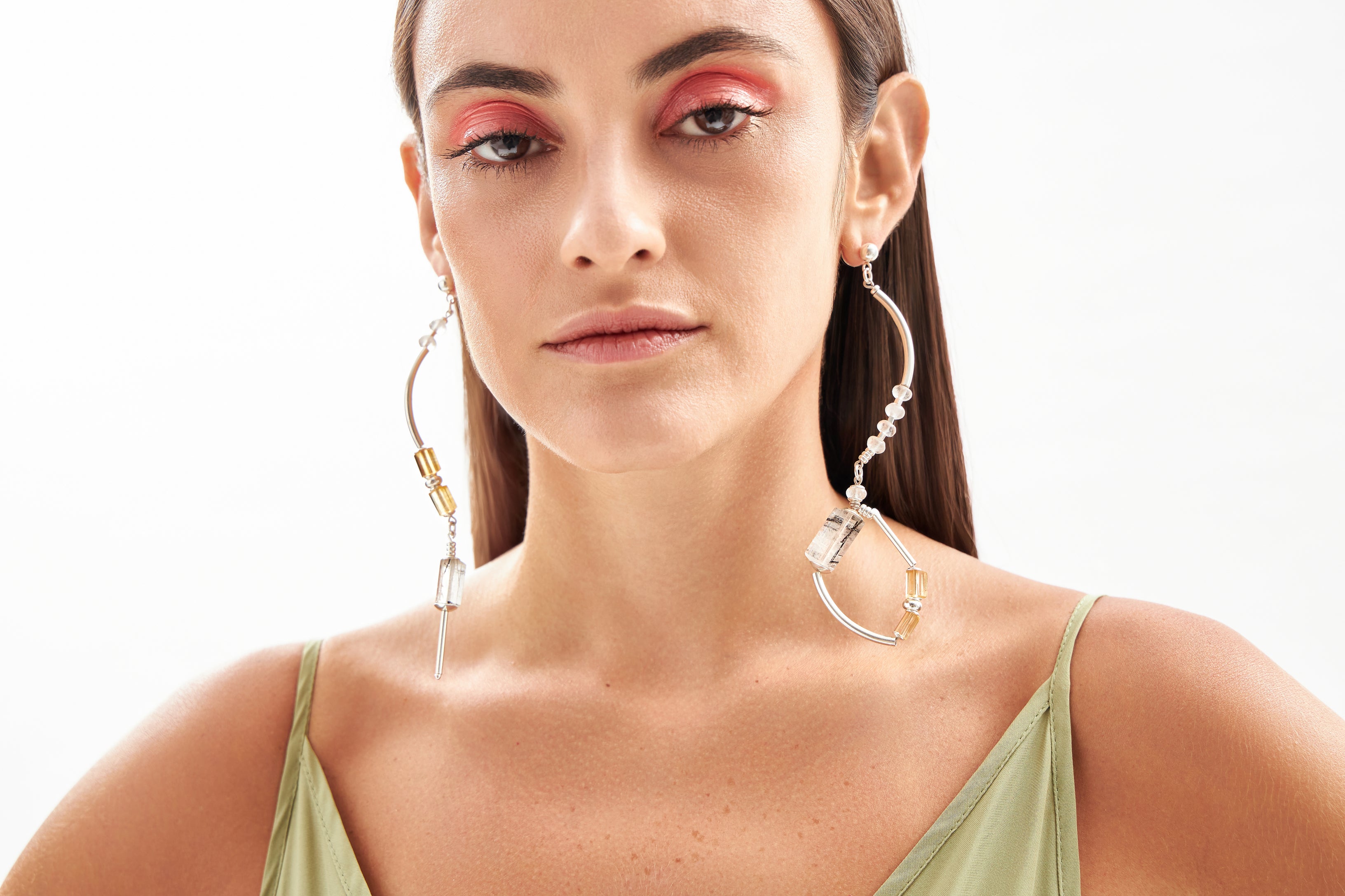 Modelo em close usando brincos Couture A'IUNE com cristais turmalinados, citrinos naturais e design assimétrico.