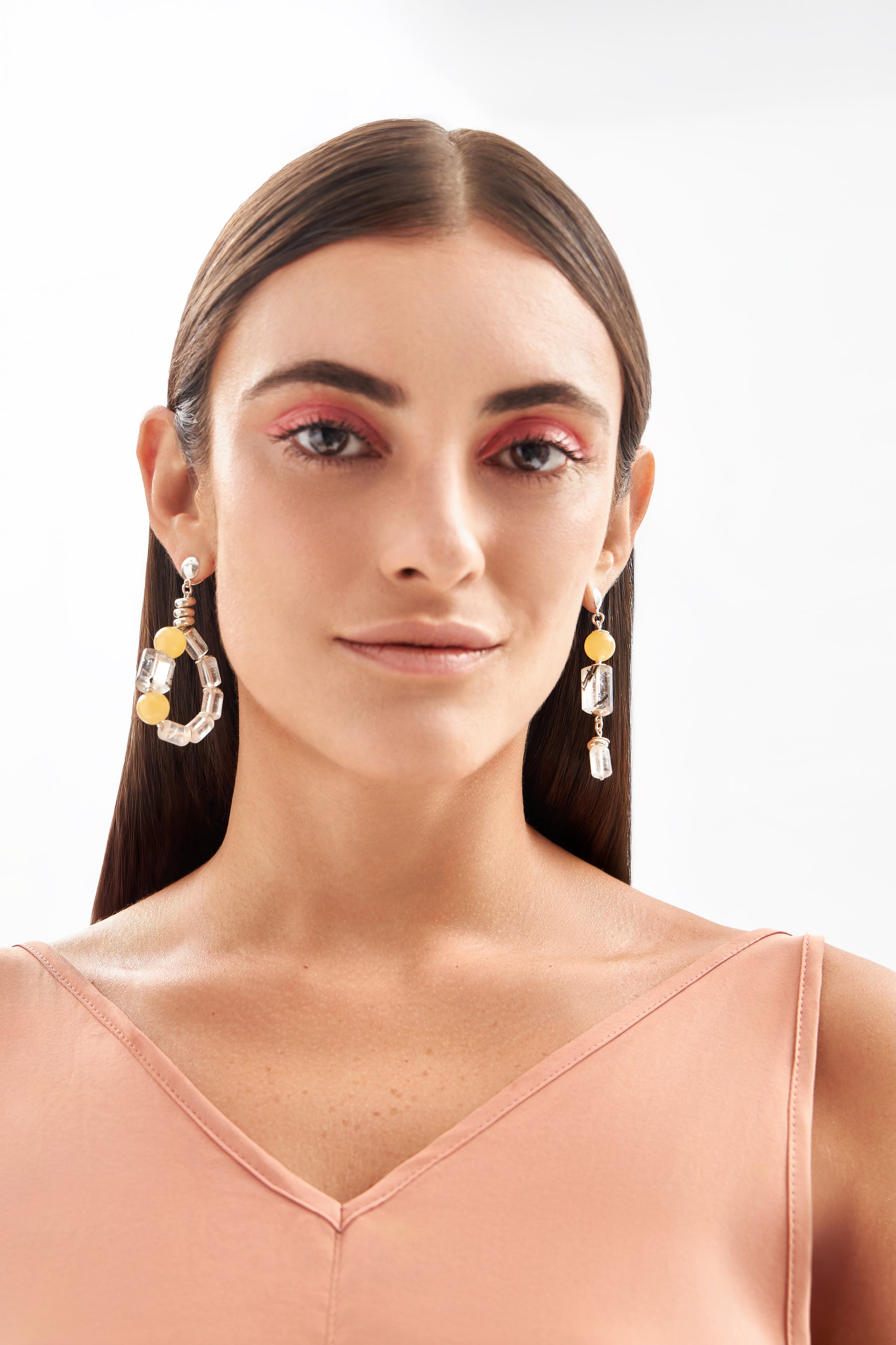 Modelo usando brincos Couture em prata 925 com cristais turmalinados, citrinos, calcita amarela e quartzo natural da A'IUNE.