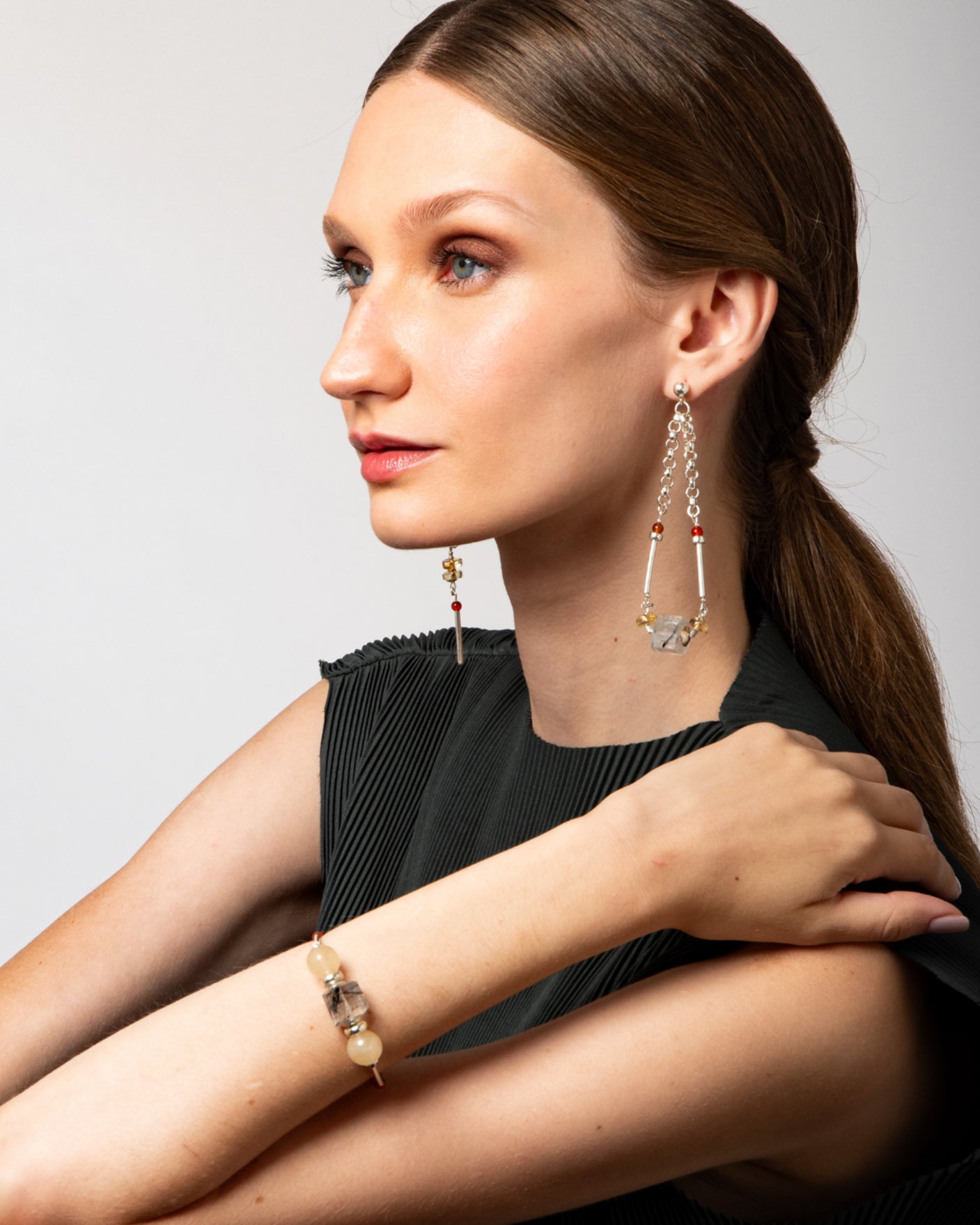 Modelo usando pulseira Couture A'IUNE com pedras naturais, design contemporâneo e estrutura regulável em prata 925.