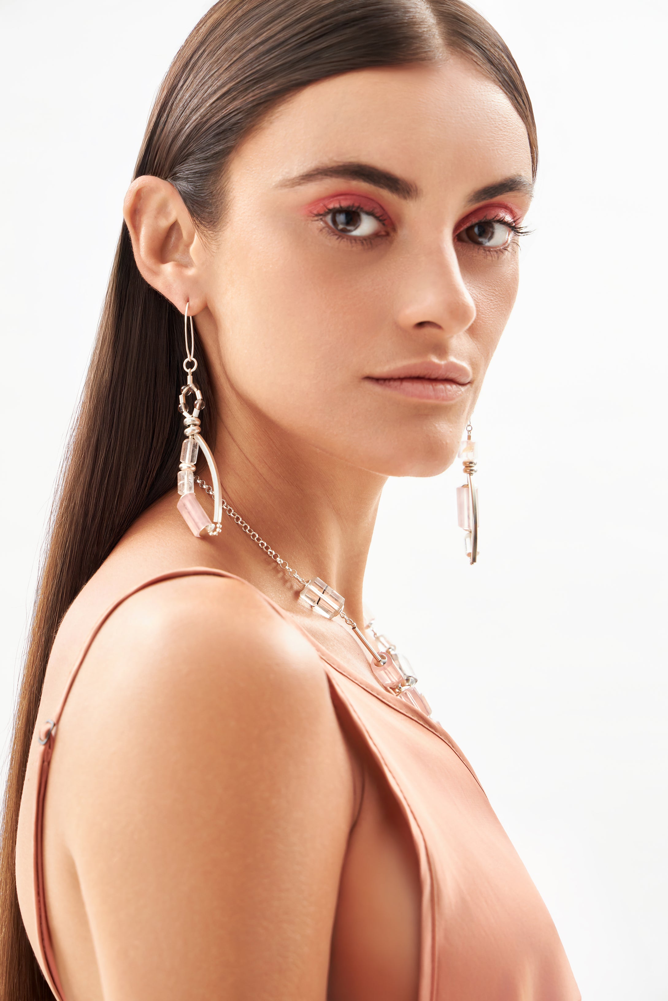 Modelo usando brincos Couture em prata 925 com quartzo rosa, âmbar e cristais naturais da A'IUNE.