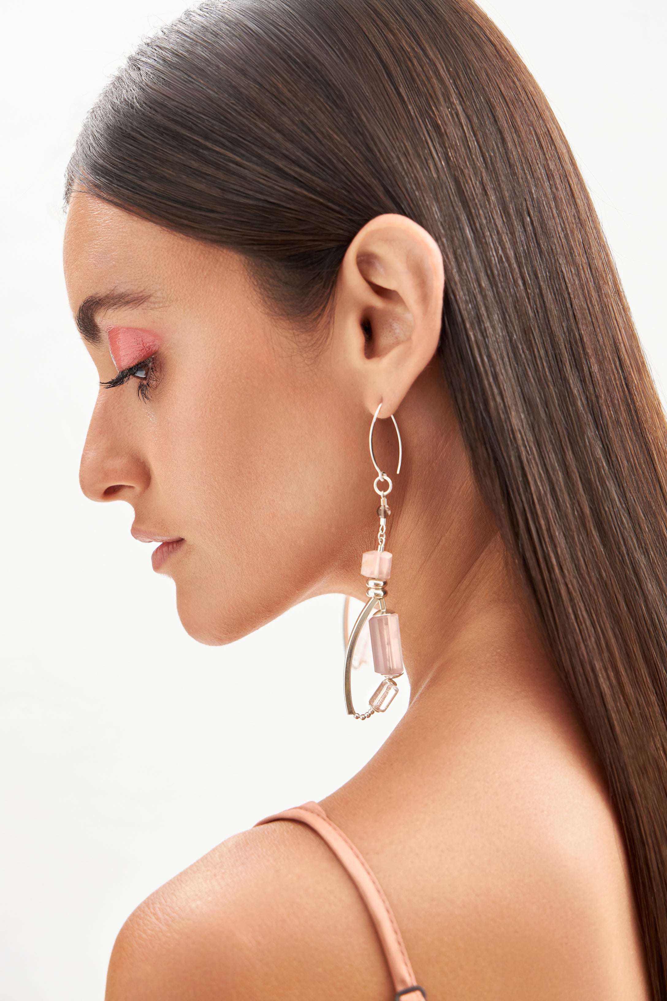 Close lateral dos brincos Couture A'IUNE com quartzo rosa, âmbar e cristais naturais em composição assimétrica.