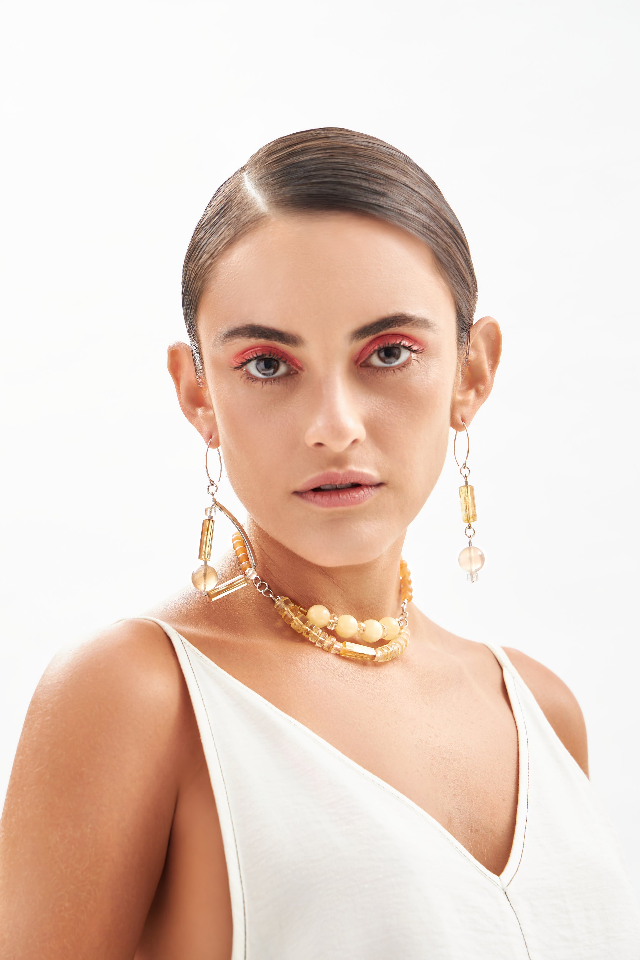 Modelo usando brincos Couture em prata 925 com citrinos e calcitas naturais, joia luminosa feita à mão pela A'IUNE.