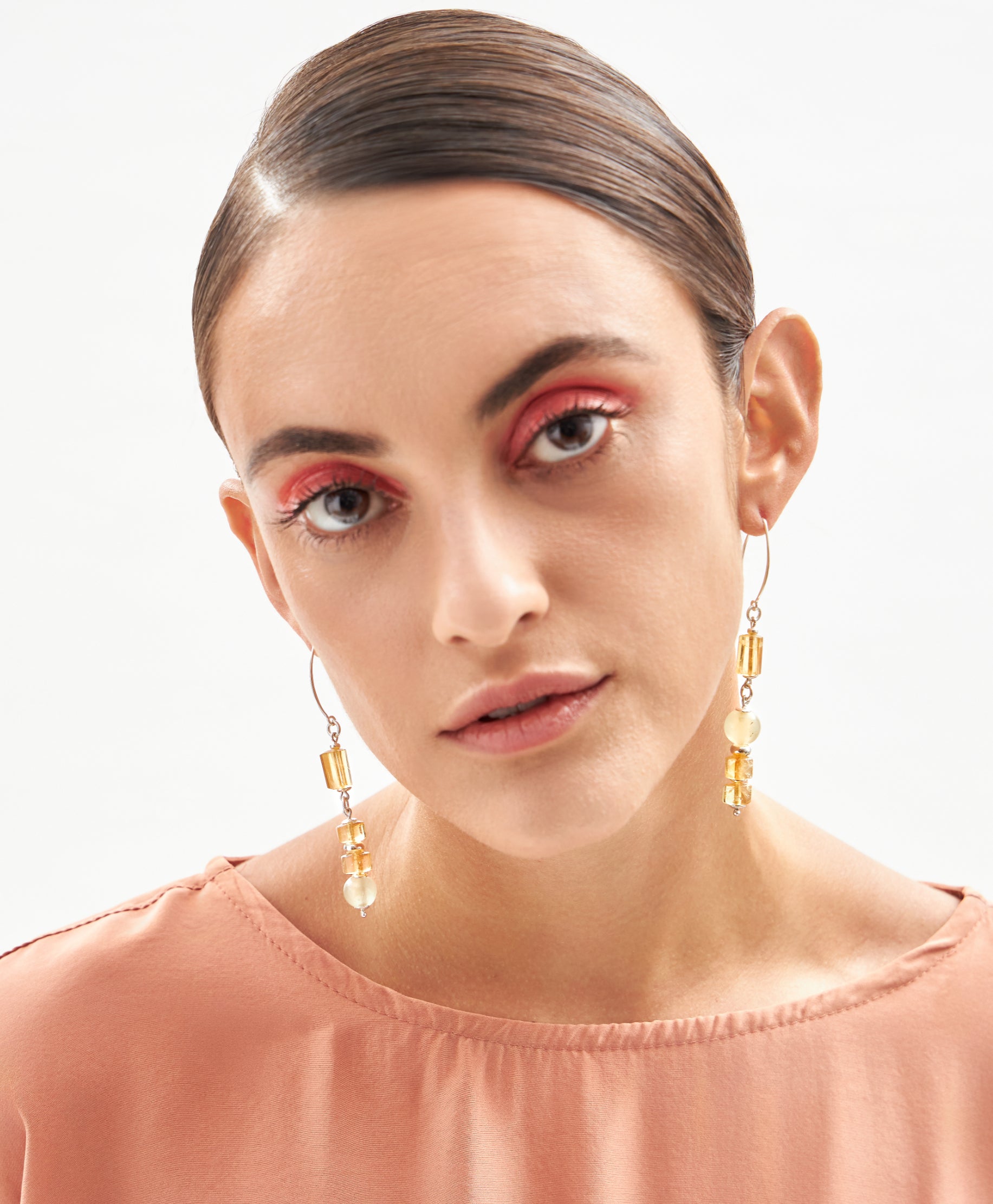 Modelo usando brincos Couture em prata 925 com citrinos e calcitas naturais, joia luminosa feita à mão pela A'IUNE.