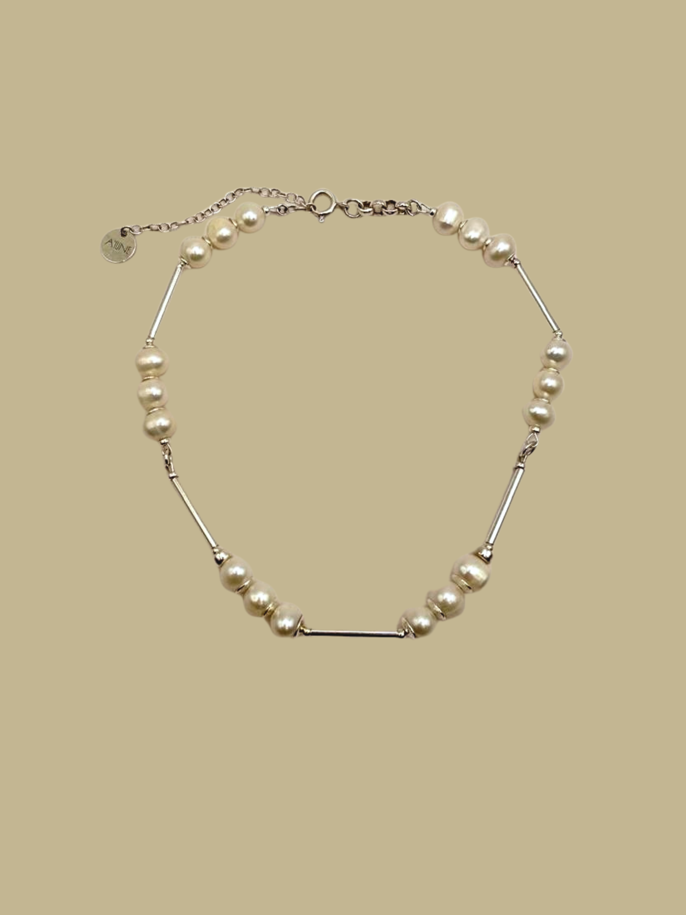 Colar Couture em prata 925 com pérolas naturais de água doce sobre fundo neutro, joia artesanal da A'IUNE.