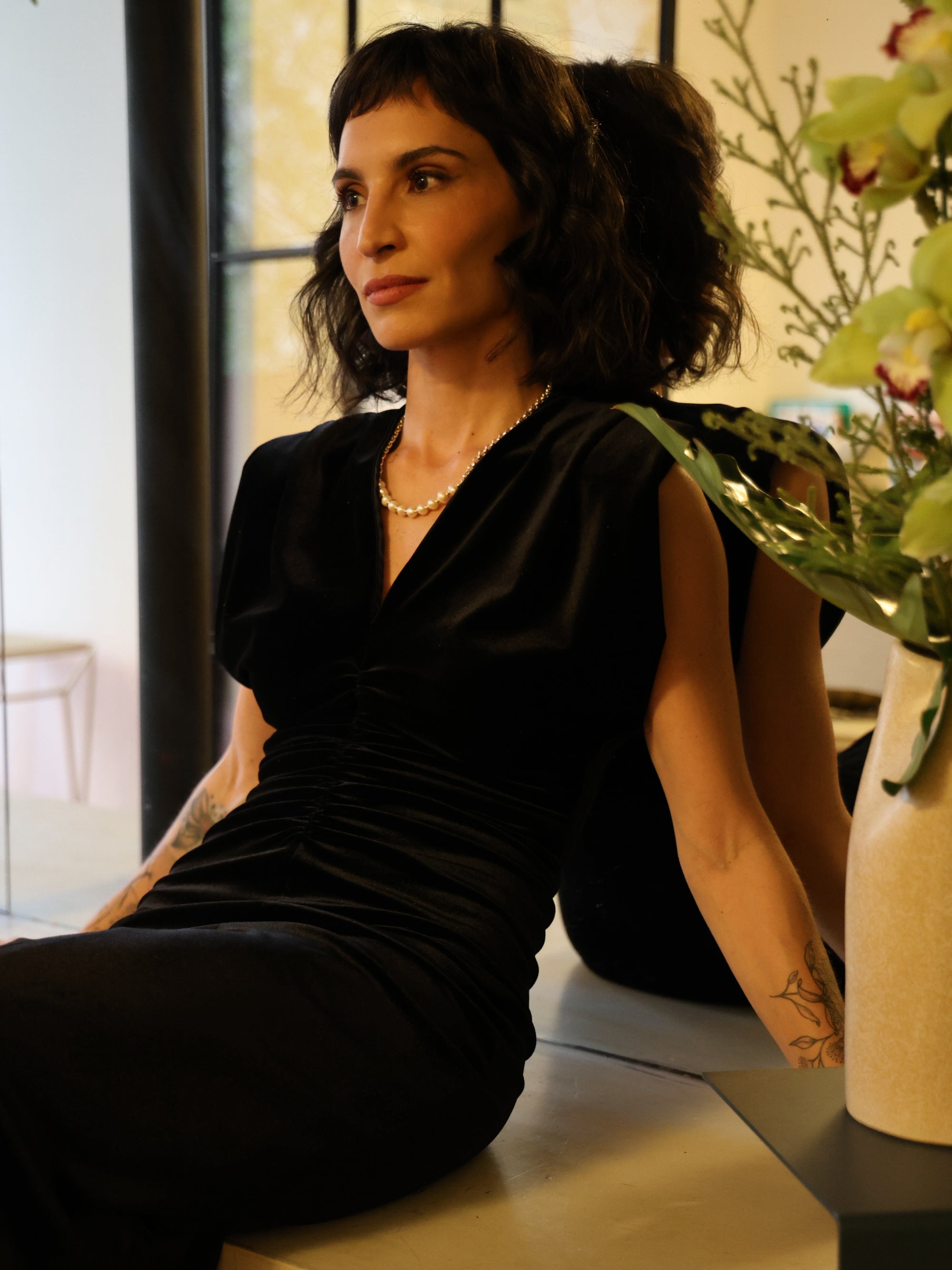 Modelo usando colar Essential A'IUNE com pérolas naturais de água doce em look preto sofisticado.