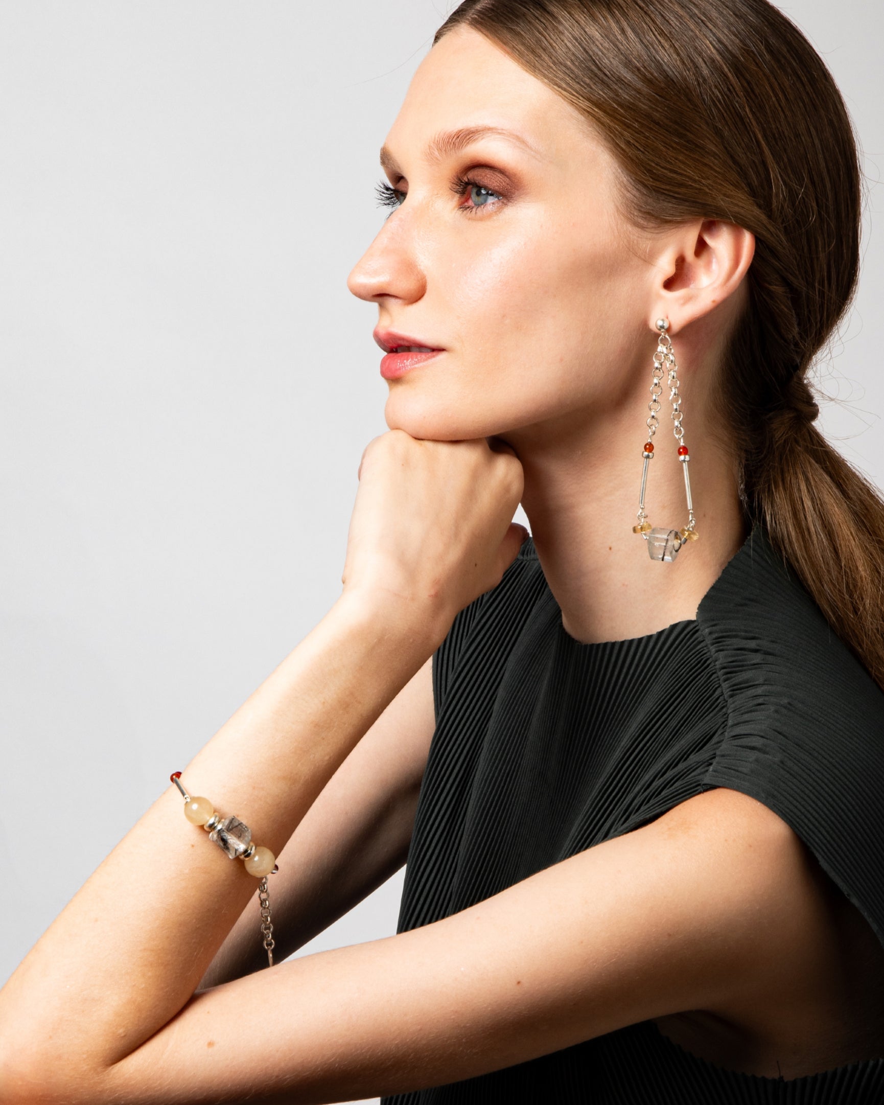 Modelo usando pulseira Couture em prata 925 com cristal turmalinado, âmbar e calcitas naturais da A'IUNE.