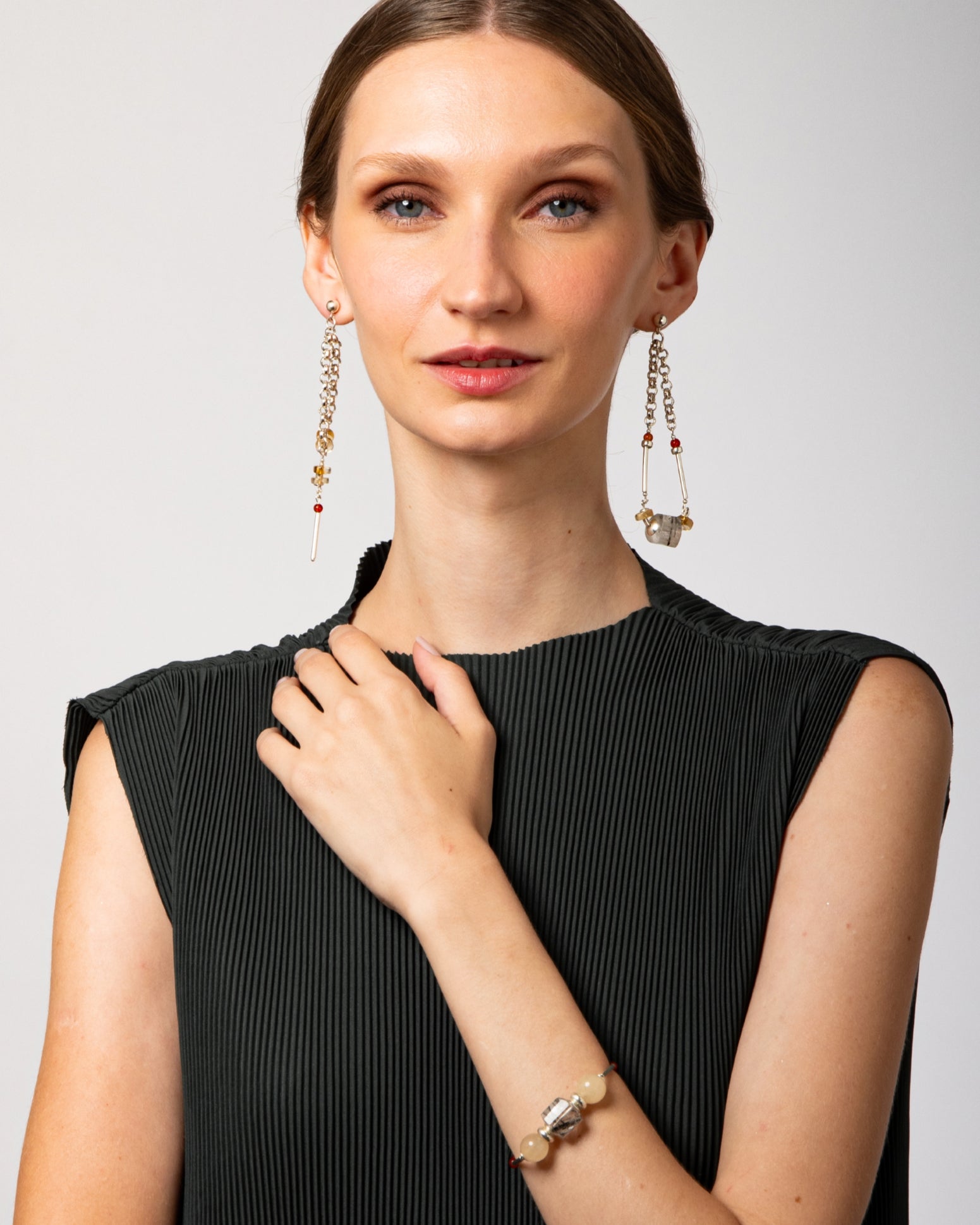 Modelo em look editorial usando pulseira Couture em prata 925 com âmbar, calcitas e cristal turmalinado.